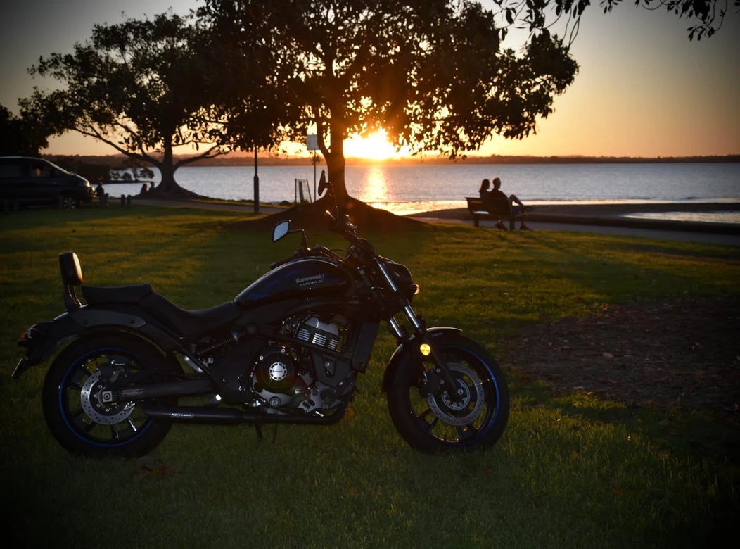 Motorcycle restoration completed, now parked in front of a breathtaking sunset.